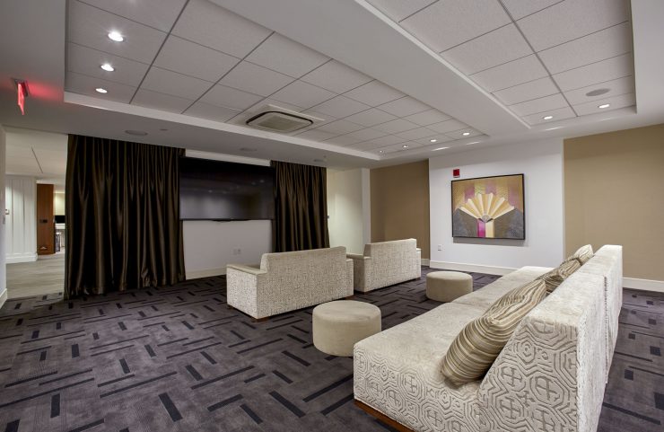media room with comfy sofas, tables and large flat screen TV