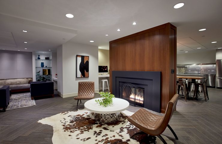club level lounge with two chairs and a table by the fireplace 