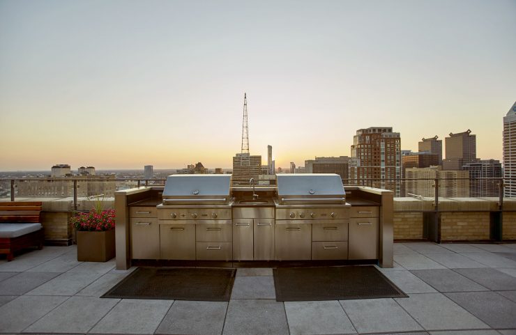 stainless steel gas grills on sky deck with sunset view of the city